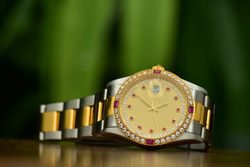 A gold watch with a gold dial and precious stones.