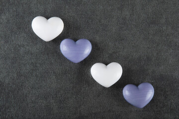 Valentine’s day background with white and purple heart on gray background.