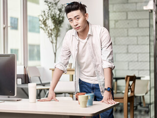 portrait of a young asian entrepreneur standing in company office