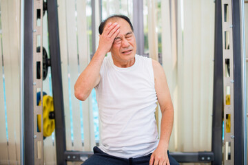 Fototapeta na wymiar Asian senior man suffering from headache in health club.