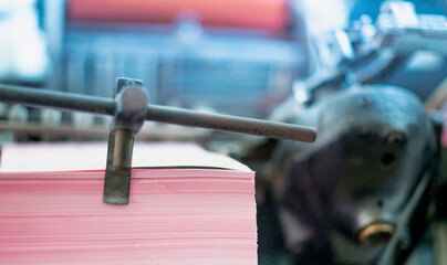 The Printed sheets of paper are served in the old printing letterpress machine with the rusty. small printing industry concept.