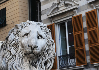 Head of an antique sad stone lion in the city of Genoa, Italy, Europe