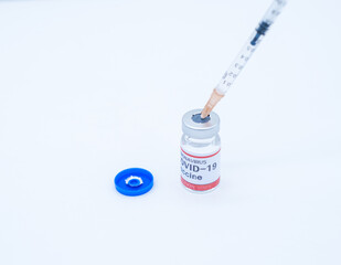 A medical syringe is inserted into the COVID-19 vaccine bottle