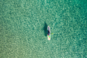 Man on Paddle Board over turquoise waters