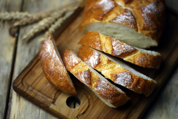 Selective focus. Fresh wheat bread on the board. Bread in slices.