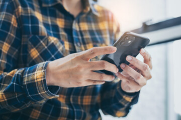 man work using cell phone hand holding mobile texting message contact us.chatting,search internet information in office.technology device communication connecting