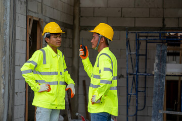Construction worker wearing safety clothing and discussing on construction site.