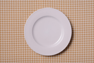 茶色いチェック柄の上の白い皿
