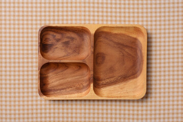 茶色いチェック柄の上に乗ったアカシアのランチプレート