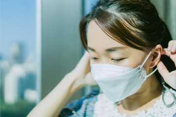 Mental health amid COVID-19 Coronavirus crisis.asian woman with mask sad and stress from financial and mental health.Lock down, Quarantine at home.Stay at home.Work from home.City and virus covid19.