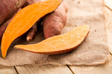 Raw sweet potato on wood background