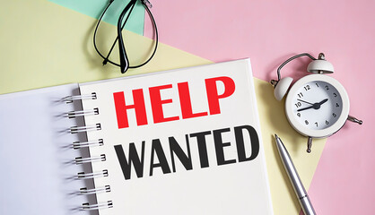 Help wanted on the notebook with pen,alarm clock on pink background