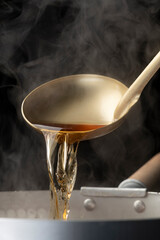 お玉で出汁を掬う