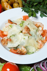 Restaurant service concept.Seafood Caesar salad with shrimp, arugula, and parmesan cheese on a round white plate.
