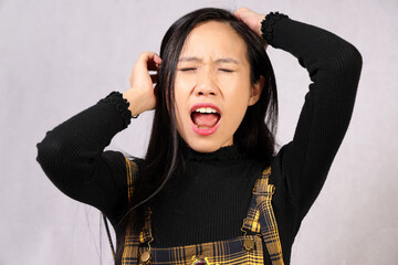 Young attractive southeast Asian woman posing facial expression angry crazy mad pain eye close