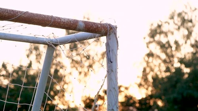 Olded football goal sports equipment with sunshine in the field.