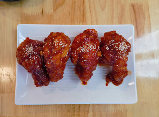 Deep fried chicken with garlic sauce in Korean style in top view on wooden table for asian food concept.