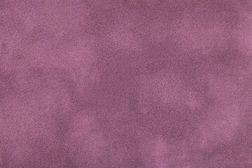 Dark purple matte background of suede fabric, closeup. Velvet texture of textile