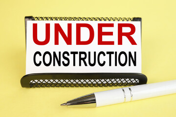 under construction. text on white paper on yellow background