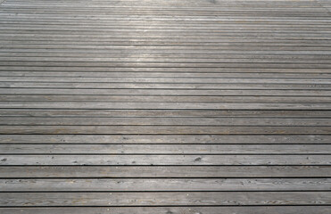 Surface of boards laid horizontally. Angle view. Natural light, sun glare.