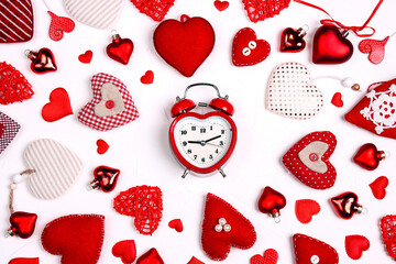 Valentine's day composition with alarm clock and many different hearts on white background.