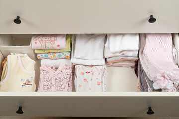 Cute newborn clothes in drawer