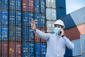 Logistic officer wearing mask and raising his hand to do not get close in container shipyard factory.Coronavirus Prevention Concept, Social Distance.