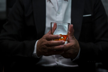 Closeup businessmen holding a glass of whiskey