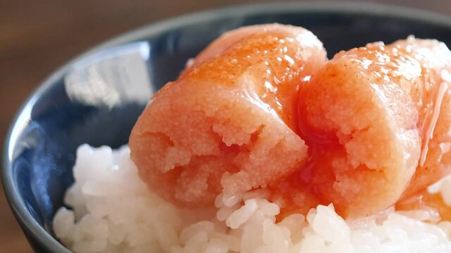 ご飯に乗せた明太子のクローズアップ。炊き立てのご飯から出てる美味しそうな湯気。