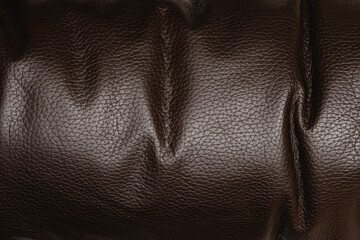Dark brown shiny leather textured background, abstract
