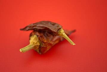 Macro image of dried red chilli pepper on red