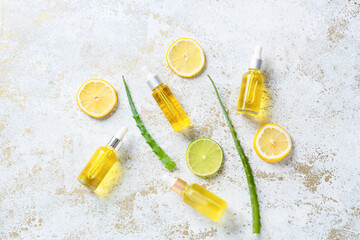 Bottles with citrus essential oil on light background