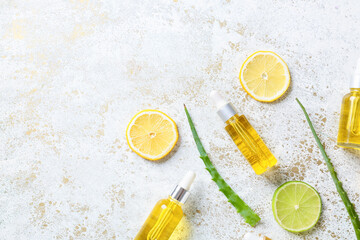 Fototapeta na wymiar Bottles with citrus essential oil on light background