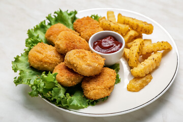 Tasty nuggets, ketchup and french fries in plate on light background