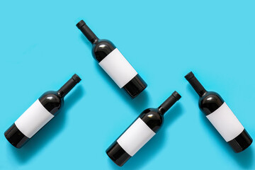 Obraz premium Bottles of wine with blank labels on color background