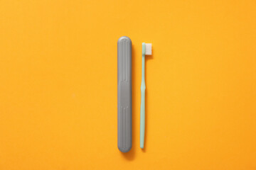 Toothbrush and case on color background