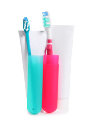 Toothbrushes, cases and paste on white background