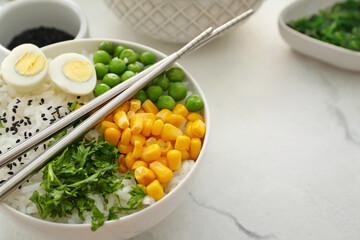 Bowl with tasty rice, eggs and vegetables on light background