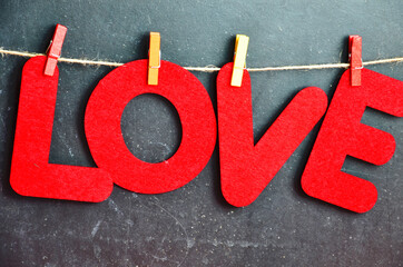 red letters hang on clothespins Valentine day and christmas background. Blurred word Love for valentine day and merry christmas