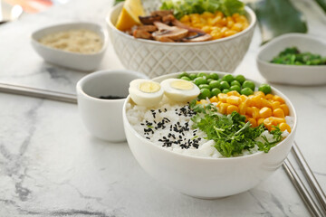 Bowls with tasty rice and vegetables on table