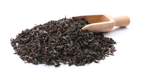 Heap of dry black tea leaves with scoop on white background