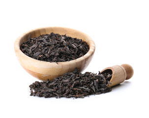 Dry black tea leaves in bowl with scoop on white background