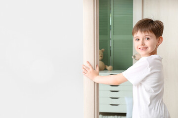 Fototapeta na wymiar Cute little boy opening bedroom door