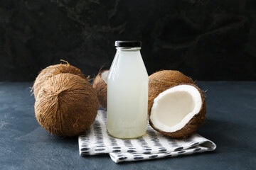 Bottle of fresh coconut water on dark background