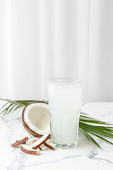 Glass of fresh coconut water on table