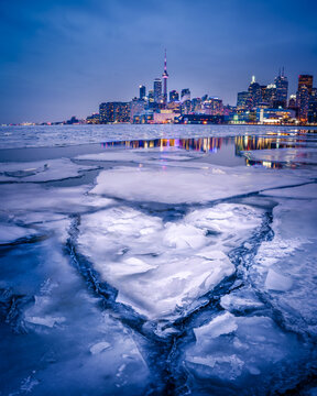 Heart shaped cracked ice in frozen lake near city