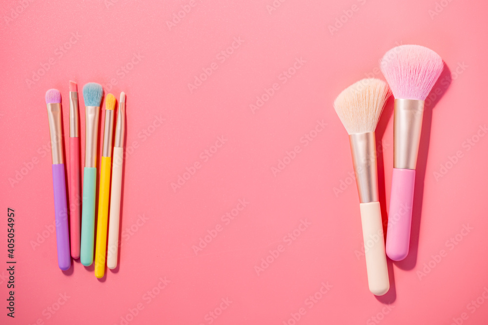 Poster make up brushes with powder on pink background