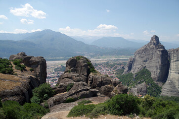 Fototapeta na wymiar Amazing view through the rocks to the mountains and the village of Kalambaka in Meteora, Greece
