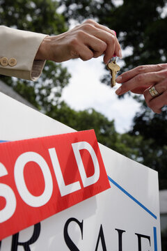 Real estate agent handing house keys to buyer
