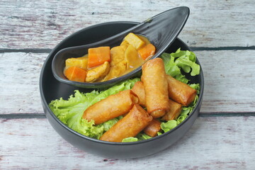 Deep fried spring roll as flour sheet wrap  fried vermicelli served with Japanese yellow curry  and sweet sauce.